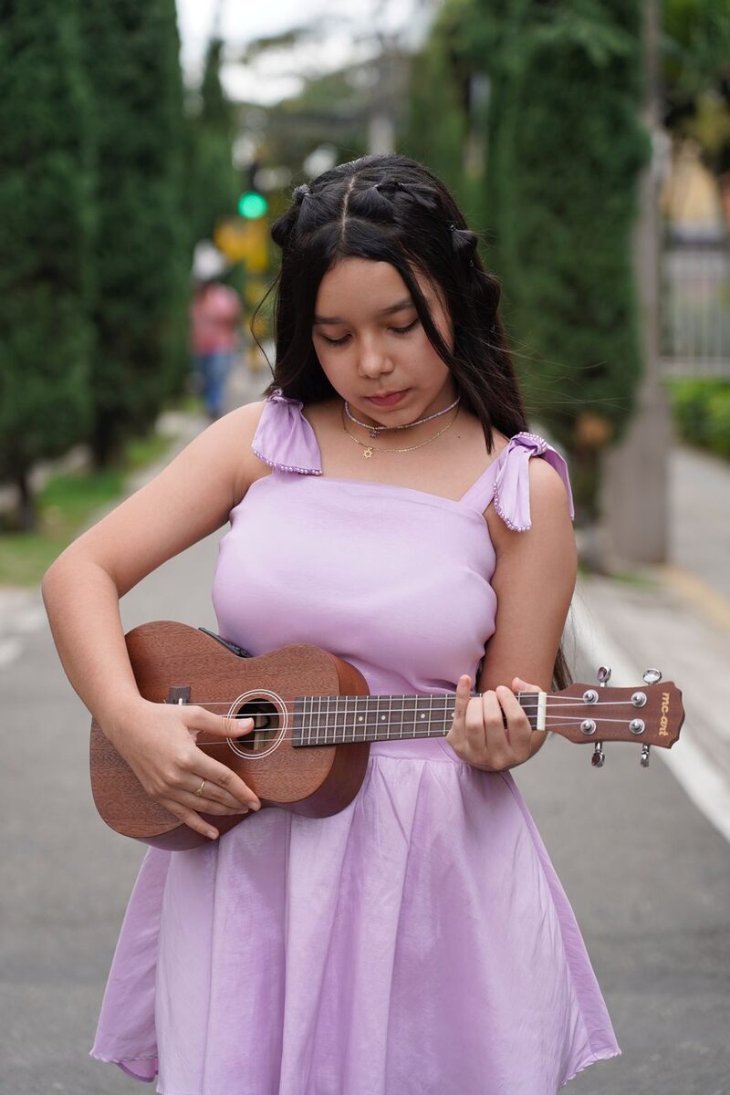 Joven tocando ukulele en la calle